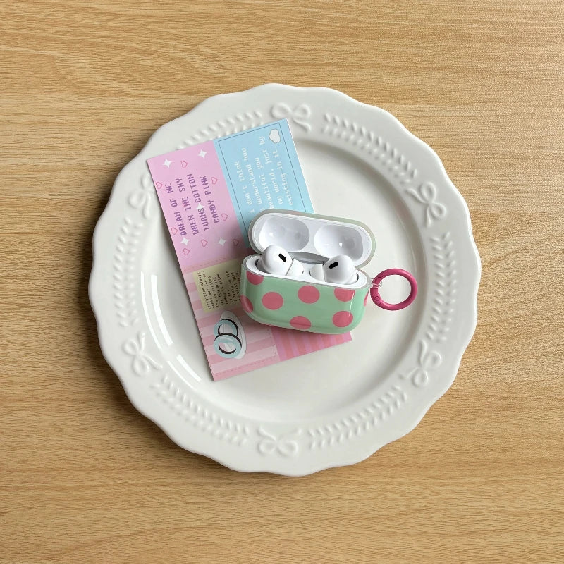 Mint and pink polka-dot AirPods case in an everyday setting
